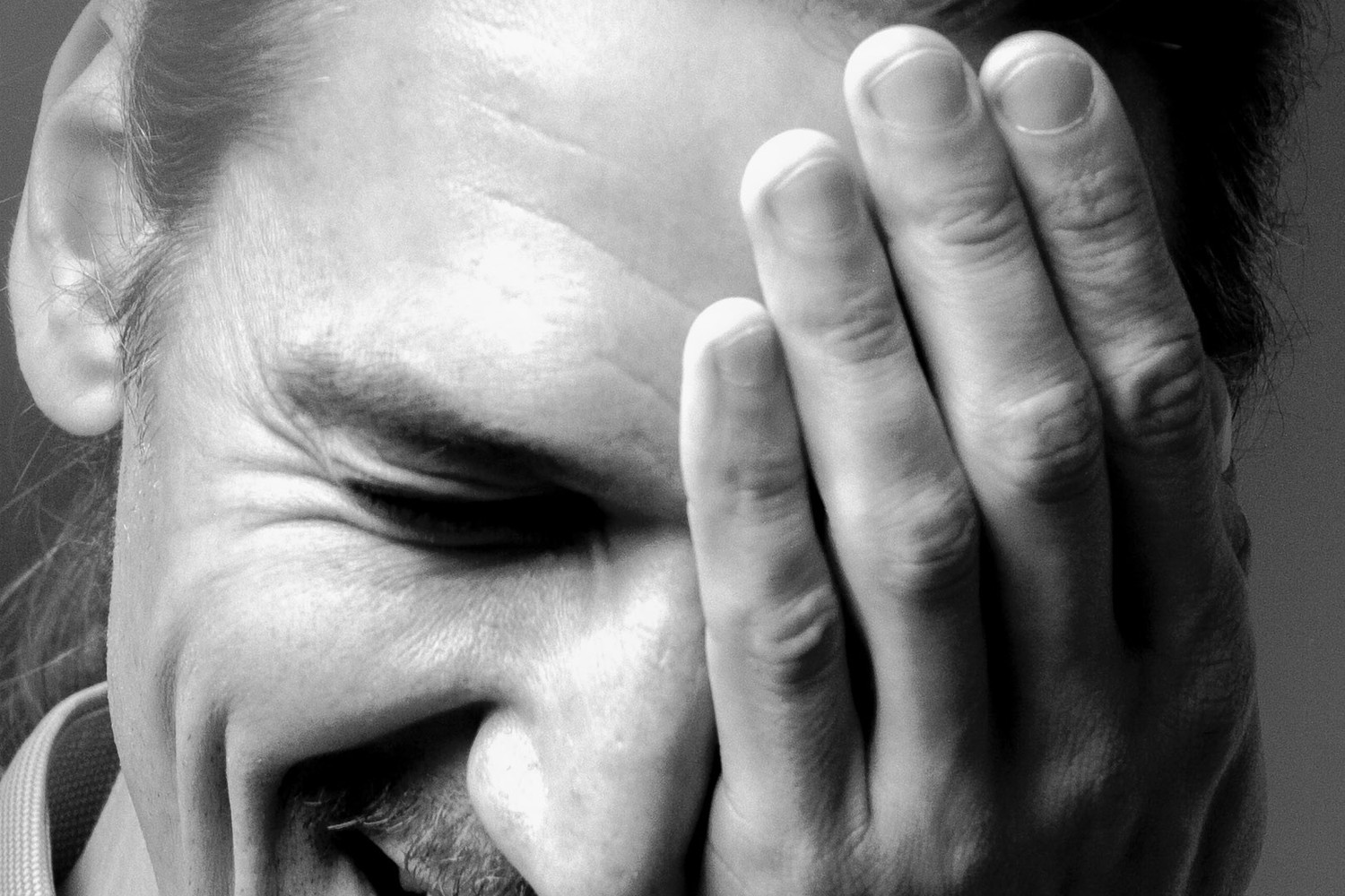 Ausschnitt aus einem Porträt der Ausstellung: Hand vor dem Gesicht
